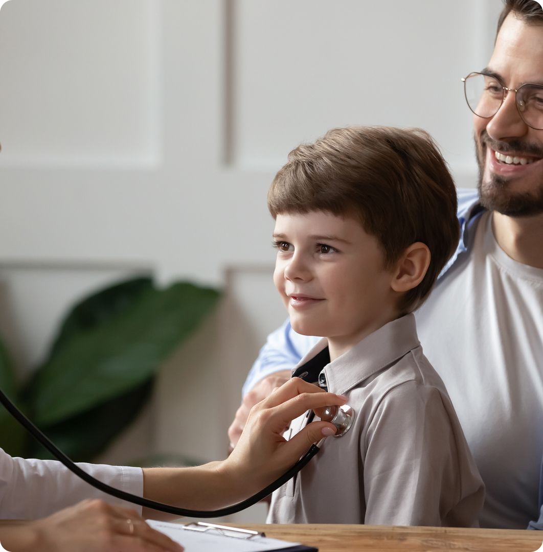Ein junge mit seinem Vater sitzt beim Arzt und wird untersucht